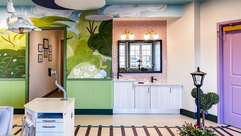 Open dental bay featuring storybook-style wall murals designed by dental architects for a child-friendly experience.