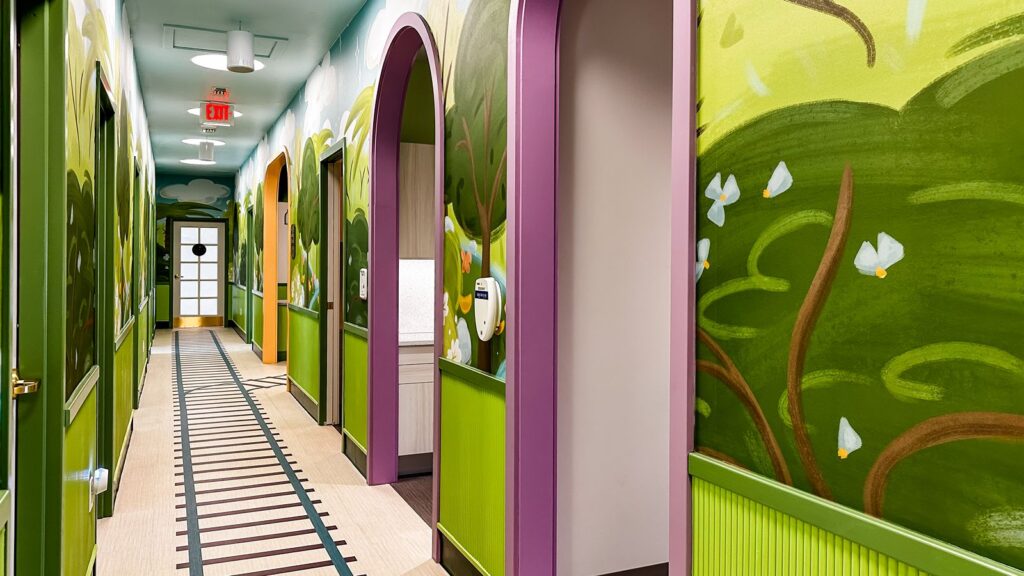 Vibrant hallway connecting dental exam rooms, showcasing dental clinic design and healthcare architecture firm creativity.