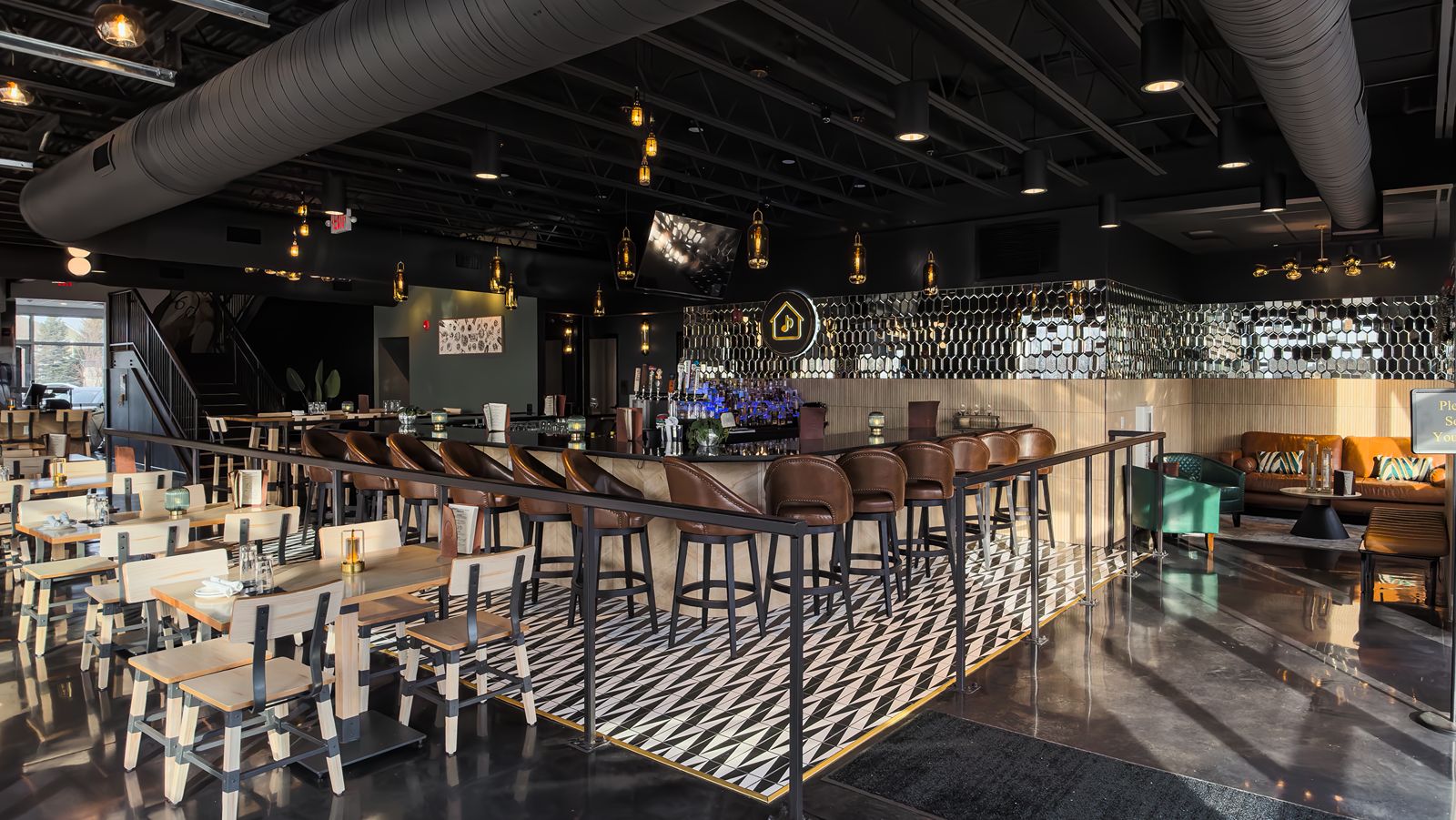 Restaurant interior with geometric tile flooring and modern bar seating.