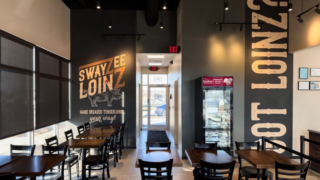 Wall mural and seating area highlighting the Swayzee Loinz brand.