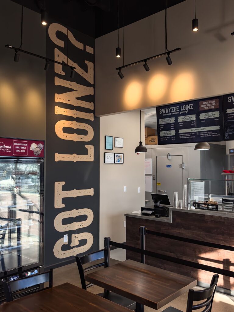 Feature wall with “Got Loinz?” typography and industrial lighting.