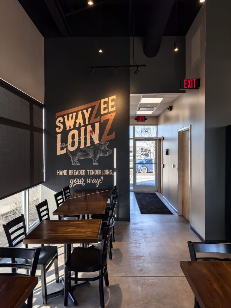 Seating area with accent wall mural and concrete floors.