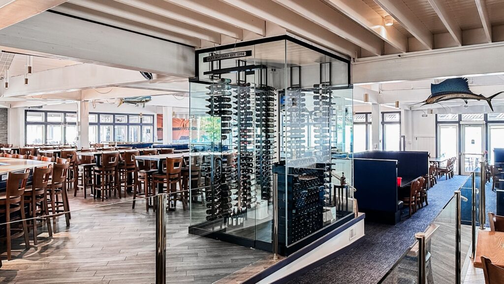 Bar area with modern lighting and glass wine cellar feature.