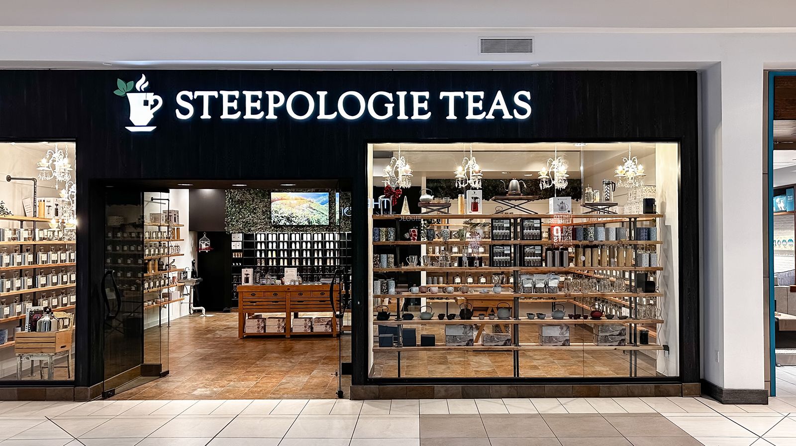 Storefront view of Steepologie Teas with illuminated signage and glass display.
