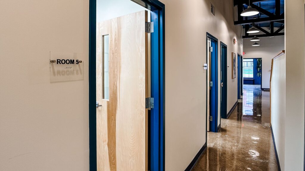 Clinical hallway featuring blue trim accents and efficient floor plan design.