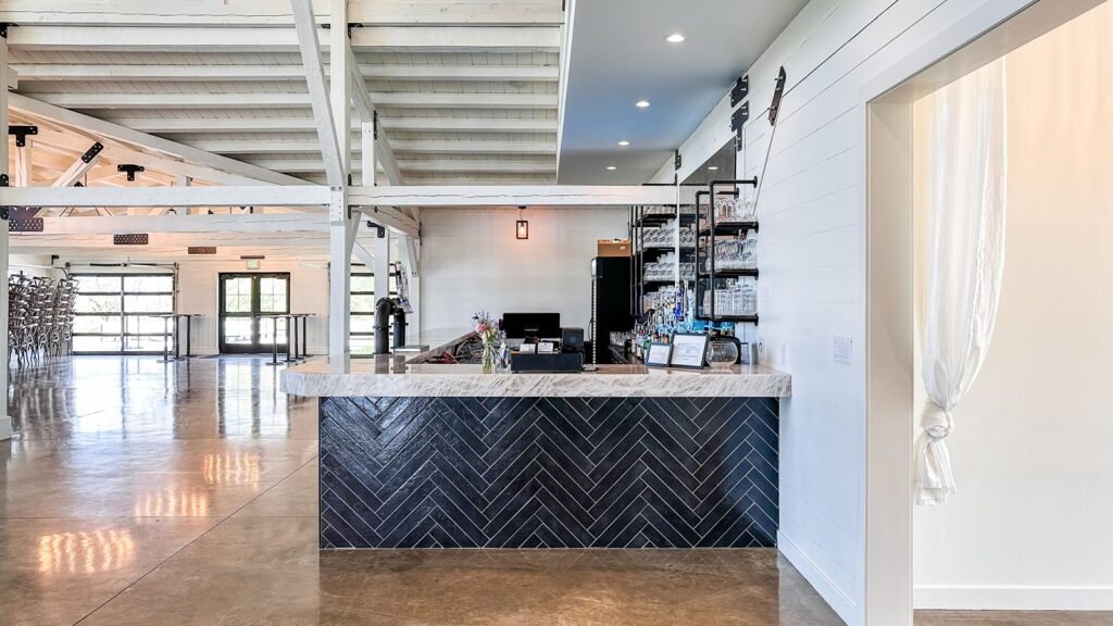 Reception bar area with herringbone tile detail and open industrial lighting design.